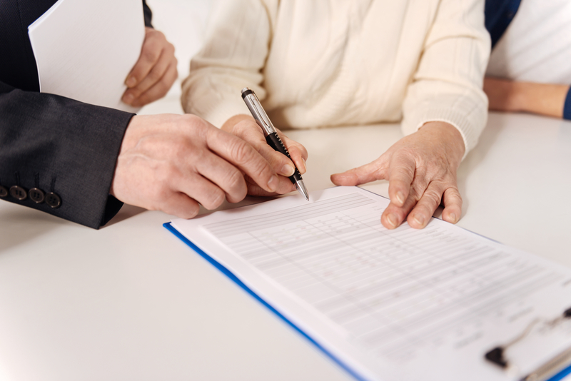 Man making older lady sign document